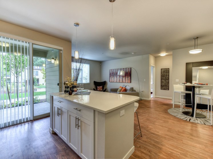 Kitchen with Bar Seating, Hardwood Inspired Floor, View of Patio and Dining Area